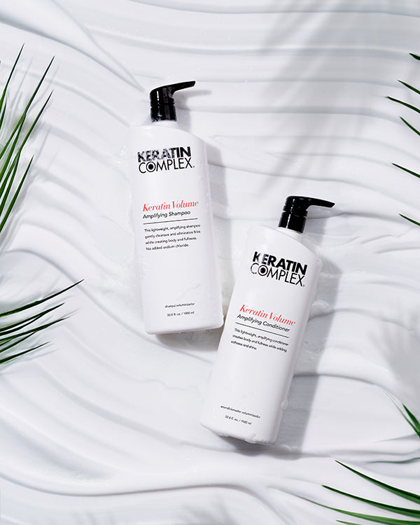 Keratin Complex UK Volume Amplifying Shampoo  and conditioner litre bottle on a white textured background 